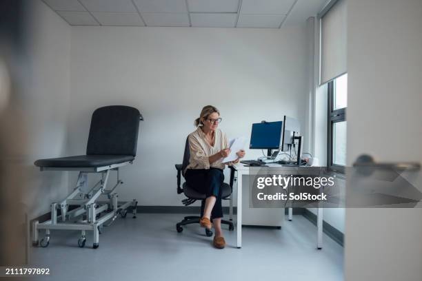 reading through the medical documents - girl power expressão inglesa imagens e fotografias de stock