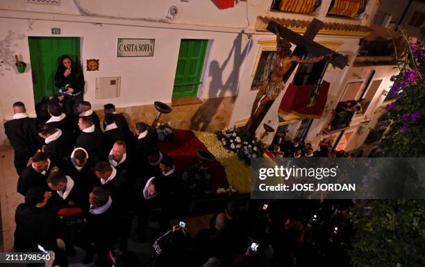 Penitents from the 'Santa Cruz' brotherhood carry an effigy of Jesus Christ on the cross up the stairs at 'Cristo de la Fe', popularly known as the...