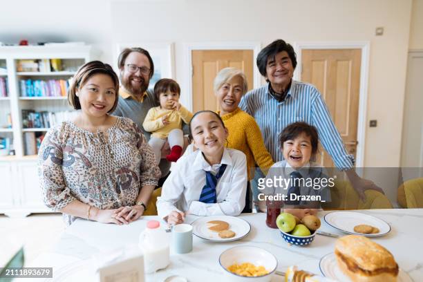 mixed asian family at home, posing in modern kitchen and looking at camera - northern european descent stock pictures, royalty-free photos & images