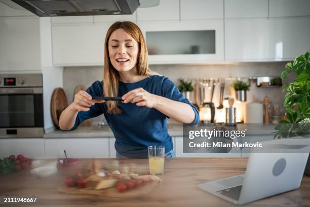 a young woman prepares breakfast in her kitchen - gorgonzola stock pictures, royalty-free photos & images