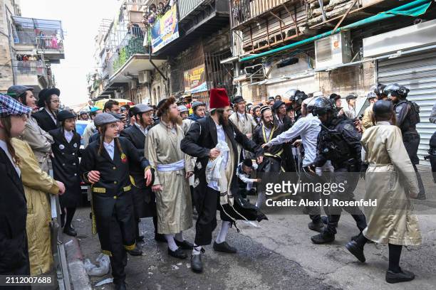 Ultra-Orthodox Jews clash with police in riot gear after a person climbed on an ambulance in the Ultra-Orthodox neighborhood of Mea Shearim, on March...