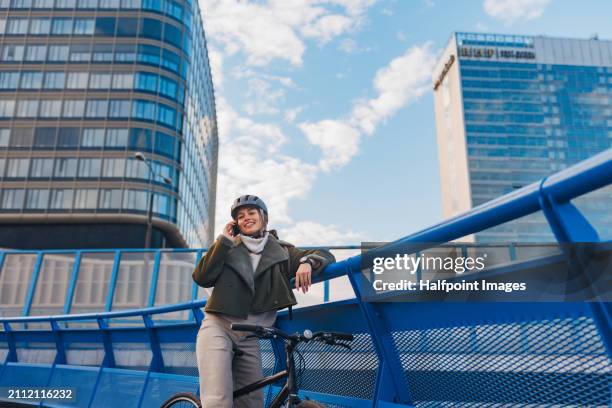 young urban woman traveling around the city by bike, stopping to make phone call on smartphone. concept of bike commuting in the city, sustainable lifestyle. - slovakia map stock pictures, royalty-free photos & images