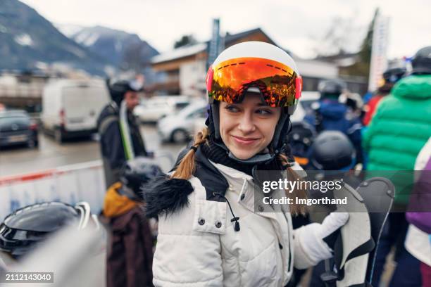 young woman preparing for skiing at an alpine ski resort. - ski stockfoto's en -beelden