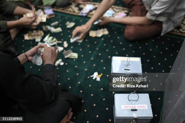 counting money in the mosque's piggy bank - man holding donation box stock pictures, royalty-free photos & images