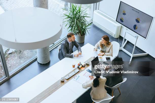 team discussion in a modern meeting space - round table discussion women stock pictures, royalty-free photos & images