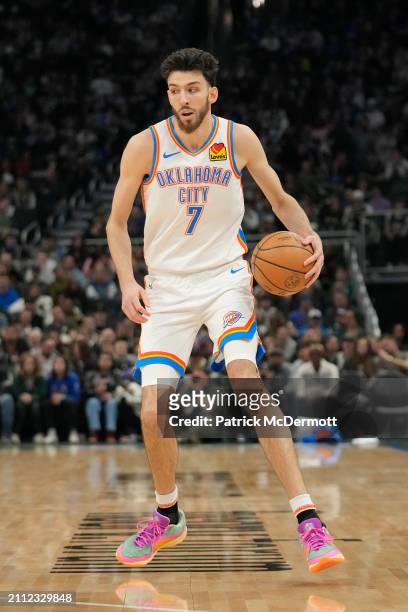 Chet Holmgren of the Oklahoma City Thunder dribbles the ball during the first half against the Milwaukee Bucks at Fiserv Forum on March 24, 2024 in...