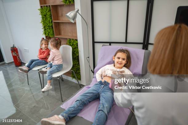 female pediatrician examining little girl with ultrasound at the medical clinic - twin ultrasound stock pictures, royalty-free photos & images