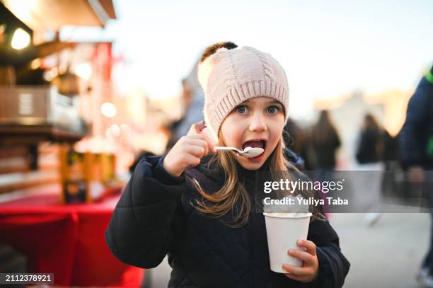 child eating whipped cream at christmas market. - christmas market close up stock pictures, royalty-free photos & images