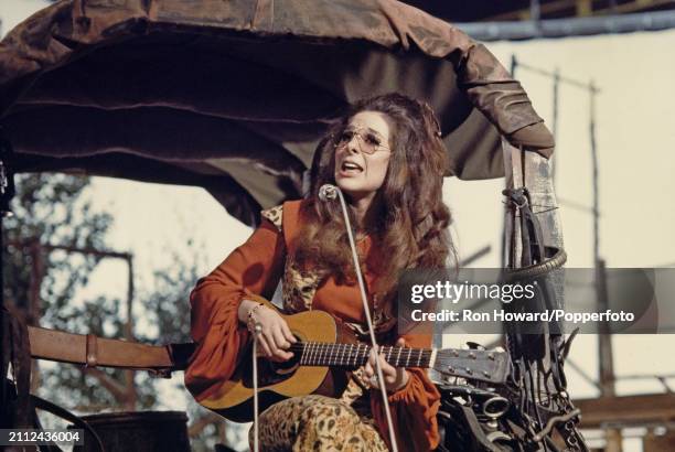 American singer Bobbie Gentry performs playing a parlor guitar on the set of a music television show in London circa 1970.