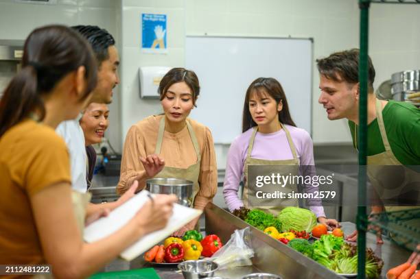 culinary mastery unveiled: asian chef's instructional session at professional cooking school - unveiled stock pictures, royalty-free photos & images