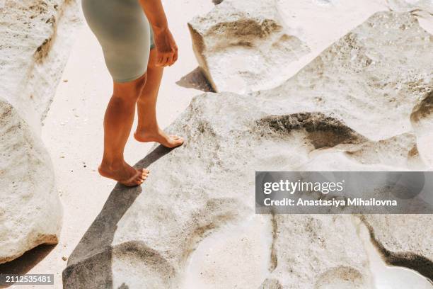 a woman in sports leggings by the ocean - female body waxing stock pictures, royalty-free photos & images