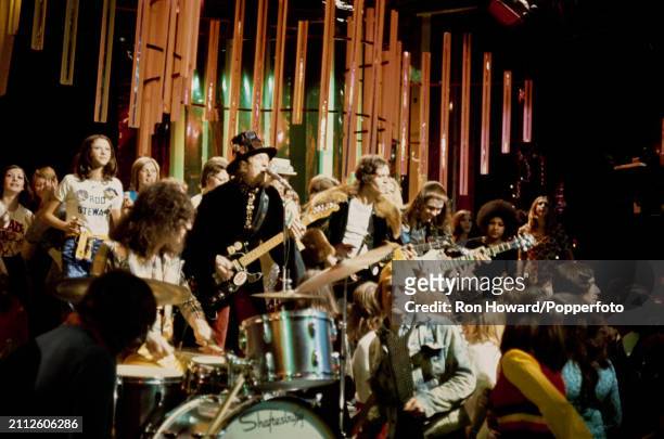 English rock group Slade perform in front of a studio audience on the set of a pop music television show in London circa 1973. Members of the band...