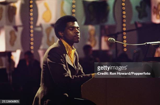 American musician and singer Billy Preston performs at a piano on the set of a pop music television show in London circa 1970.
