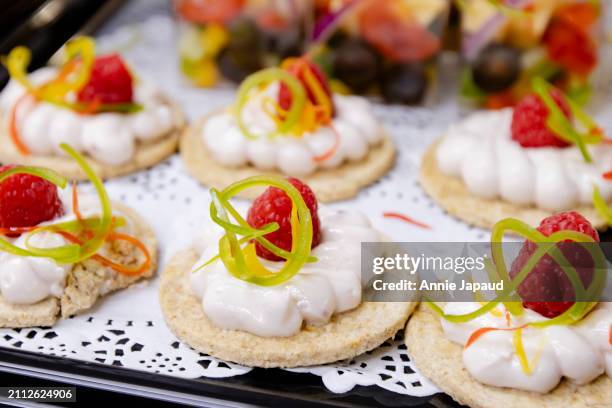 whipped cheese on cracker, canapes topped with fresh raspberry, party food - prosciutto stock pictures, royalty-free photos & images