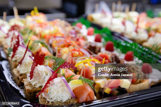 rows of canapes lined on black party trays, catering platters. savory mini food bites - prosciutto stock pictures, royalty-free photos & images