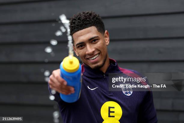 Jude Bellingham of England sprays a bottle of Lucozade at Tottenham Hotspur Training Centre on March 25, 2024 in Enfield, England.