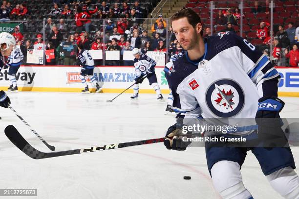 Colin Miller of the Winnipeg Jets skates during warm up prior to the game against the New Jersey Devils at the Prudential Center on March 21, 2024 in...