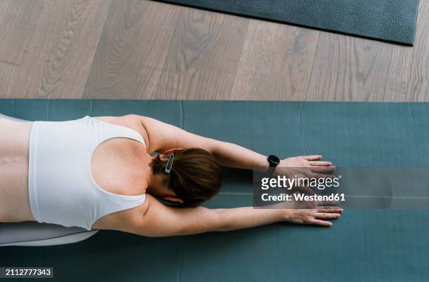 woman doing child's yoga pose at gym - child yoga elevated view stock pictures, royalty-free photos & images