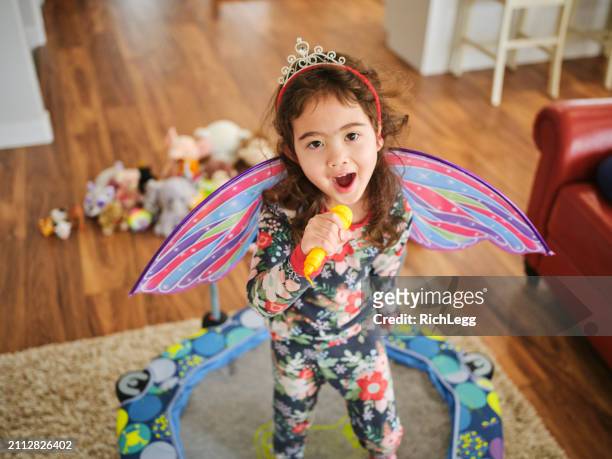 preschooler playing a make-believe concert - gig living room stock pictures, royalty-free photos & images