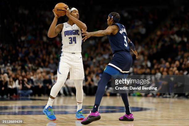 Wendell Carter Jr. #34 of the Orlando Magic looks to pass against Jaden McDaniels of the Minnesota Timberwolves in the fourth quarter at Target...