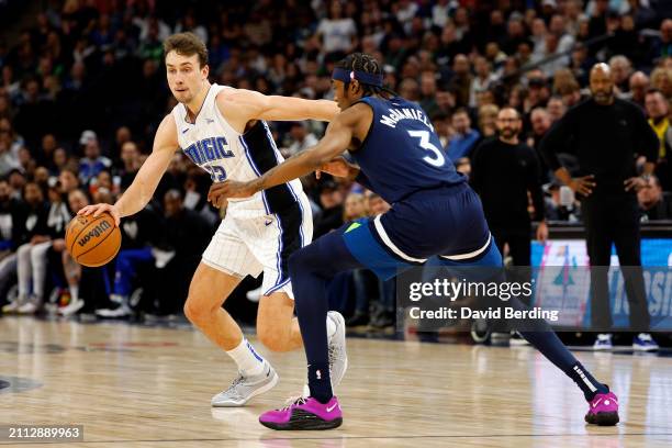 Franz Wagner of the Orlando Magic dribbles the ball against Jaden McDaniels of the Minnesota Timberwolves in the fourth quarter at Target Center on...