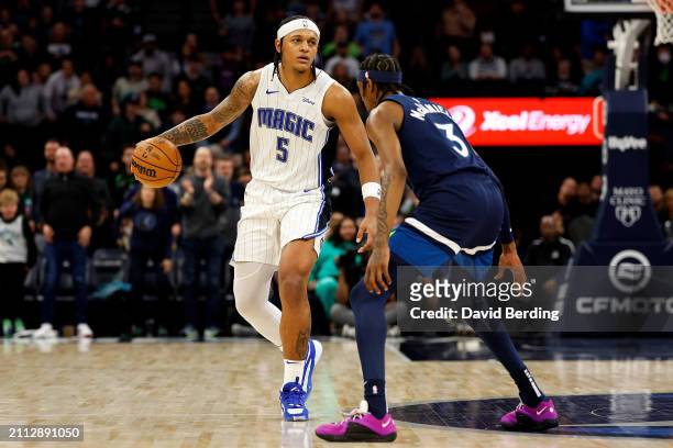 Paolo Banchero of the Orlando Magic dribbles the ball against Jaden McDaniels of the Minnesota Timberwolves in the fourth quarter at Target Center on...