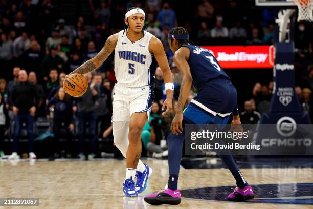 Paolo Banchero of the Orlando Magic dribbles the ball against Jaden McDaniels of the Minnesota Timberwolves in the fourth quarter at Target Center on...