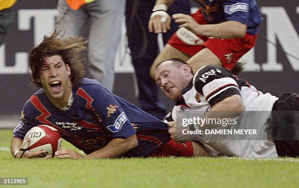 Stade Francais' fullback, Argentinian Ignacio Corleto scores the second try of his team despite the tackle of Stade Toulous ain's flanker Trevor...