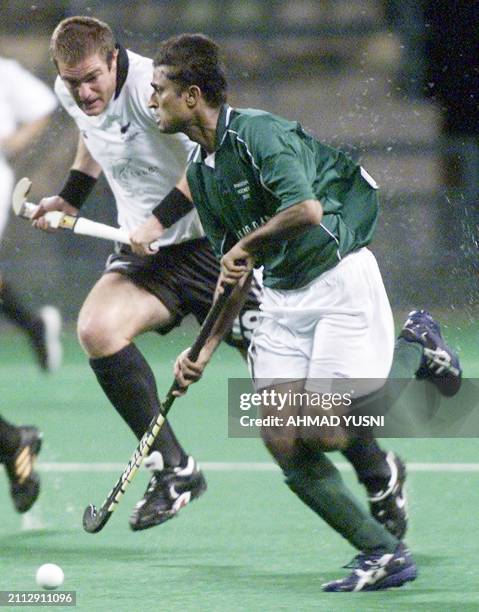 Pakistan's Shahbaz Ahmed controls the ball while New Zealand's Hayden Shaw trying to challenge during 6-Nation Mens Invitational Tournament in Kuala...