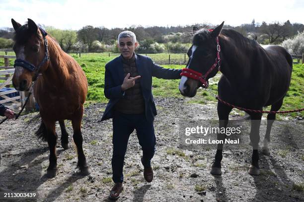 London mayor Sadiq Khan poses with horses Prince and Perry at Green Gates stables in Barnet on March 28, 2024 in London, England. The Mayor of London...