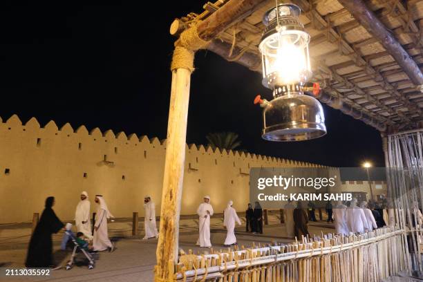 Emiratis and other visitors tour the venue of the annual traditional crafts and industries heritage festival in Qattara market in the Gulf emirate of...