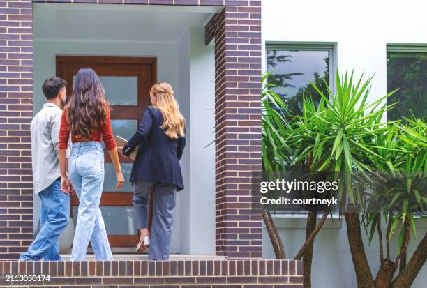 real estate agent showing a couple a new house. - renting stock pictures, royalty-free photos & images
