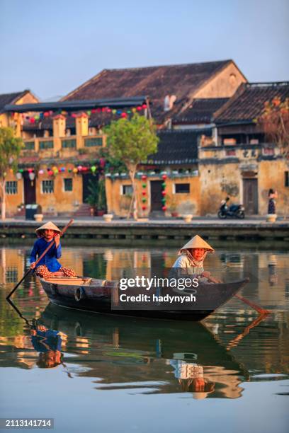 vietnamese women riding a boat, old town in hoi an city, vietnam - hoi an stockfoto's en -beelden