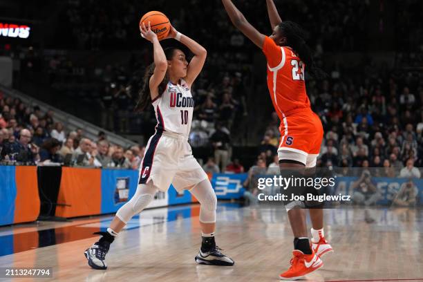 Nika Muhl of the Connecticut Huskies looks for the open pass against Alyssa Latham of the Syracuse Orange during the first half of a second round...