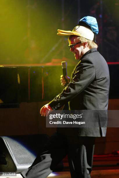 British singer songwriter Sir Elton John, wearing a Donald Duck hat, performs on stage at the Old Vic Theatre in London on February 5, 2003. The...