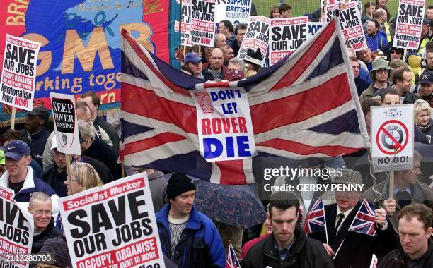 Rover workers and their supporters hold banners with slogans during a march from Birmingham City centre to Cannon Hill Park 01 April 2000. More than...