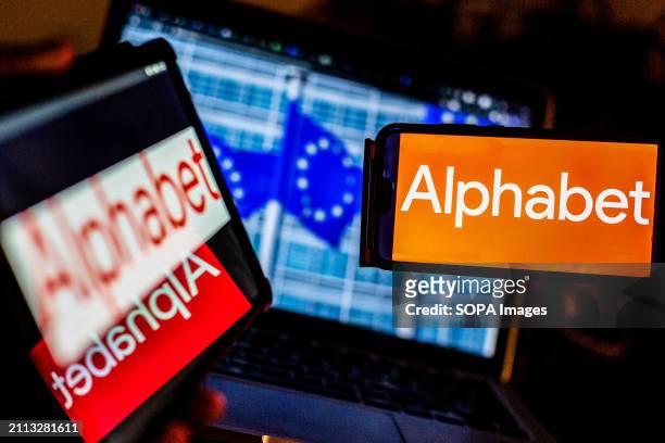 In this photo illustration, an Alphabet logo seen on a smartphone and tablet screens against a screen displaying a photograph of European Union...