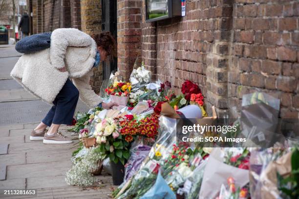 Mourner places a bouquet of rose in London for the memories of the victims of the concert hall massacre in Moscow by the entrance gate of the Russian...