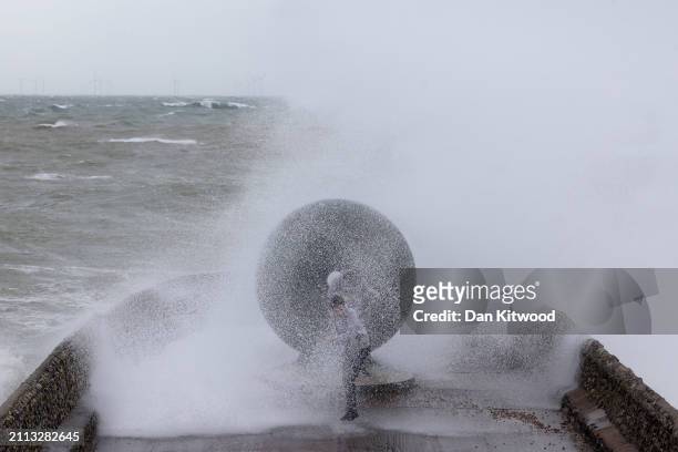 Person is hit by a wave as Storm Nelson batters the coastal regions on March 28, 2024 in Brighton, England. Storm Nelson had already hit parts of...