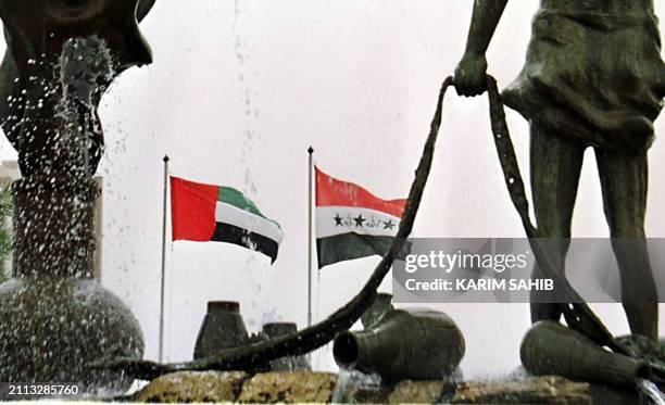 Picture taken through a sculpture depicting a scene from the 'Arabian Nights' in central Baghdad shows the flags of Iraq and the United Arab Emirates...