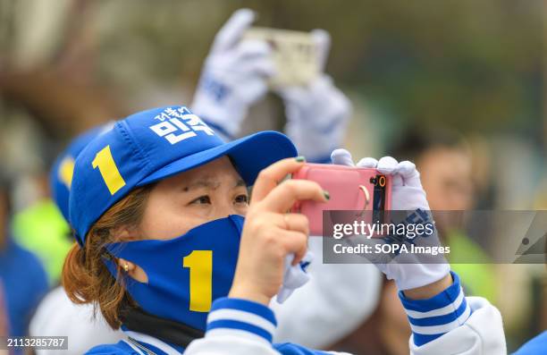 Supporters of South Korea's main opposition Democratic Party take candidates pictures during a campaign event for the upcoming parliamentary...