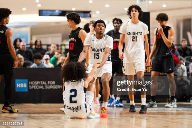 Angelino Mark of the Blue Knights is helped up during the game against the Columbus Explorers during The Throne high school basketball tournament on...