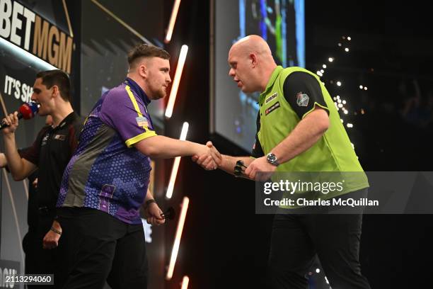 Luke Littler is congratulated by Michael van Gerwen following their semifinal match at The SSE Arena Belfast on March 28, 2024 in Belfast, Northern...