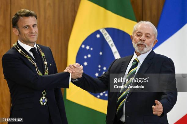 Brazil's President Luiz Inacio Lula da Silva awards French President Emmanuel Macron with the Order of the Southern Cross decoration at the Planalto...