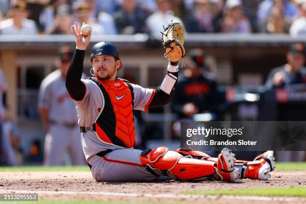 Patrick Bailey of the San Francisco Giants calls for time after tagging out Jose Azocar of the San Diego Padres in the fifth inning during an Opening...