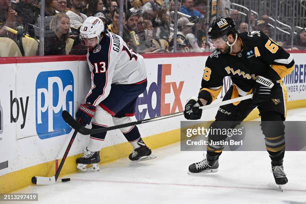 Johnny Gaudreau of the Columbus Blue Jackets battles along the boards with Kris Letang of the Pittsburgh Penguins in the second period during the...