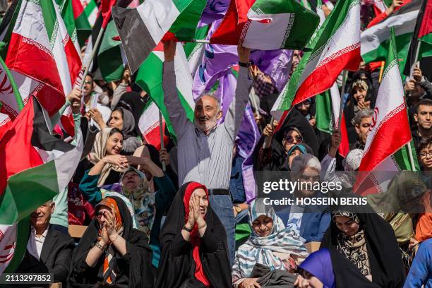 Iranian people wave Iranian and Palestinian flags during a rally in solidarity with Palestinians in Azadi Stadium in Tehran, Iran on March 26, 2024....