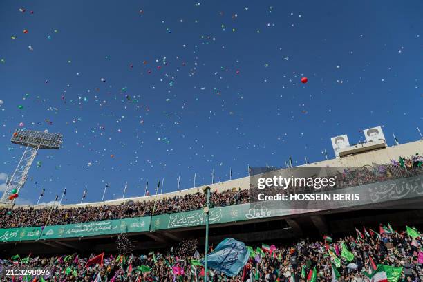 Iranian people wave Iranian and Palestinian flags during a rally in solidarity with Palestinians in Azadi Stadium in Tehran, Iran on March 26, 2024....