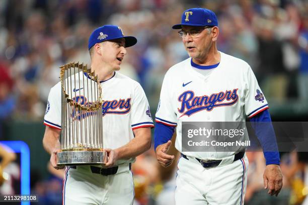 Josh Sborz and manager Bruce Bochy of the Texas Rangers present the Commissioner's trophy prior to the game between the Chicago Cubs and the Texas...