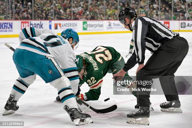 Luke Kunin of the San Jose Sharks and Marat Khusnutdinov of the Minnesota Wild face off during the second period at Excel Energy Center on March 28,...